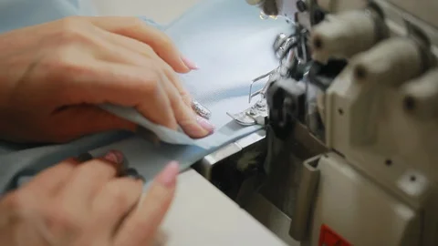 Woman's hands sewing an overlock at sewing machine. Overlock stitch on sewing Video stock 97156727