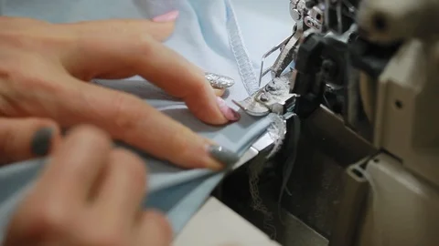 Woman's hands sewing an overlock at sewing machine. Overlock stitch on sewing Video stock 97156807