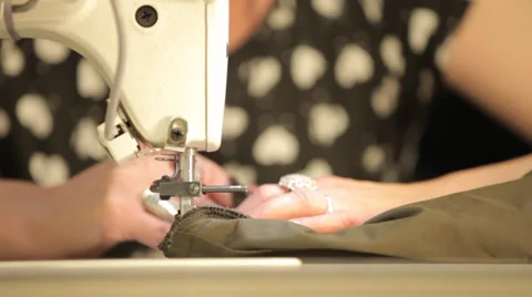 Woman's hands sewing with a sewing machine in a dressmaker's factory Stock Footage 31442539