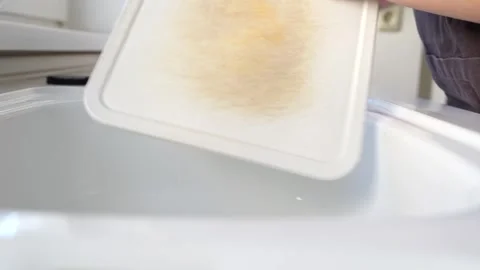 Woman's hands shaking bread crumbs into sink Stock Footage 251664959