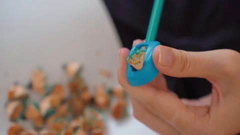 Woman's hands sharpening a pencil above paper Video stock 328589865