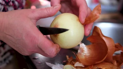 Woman's hands skillfully peeling a yellow onion Stock Footage 302076785