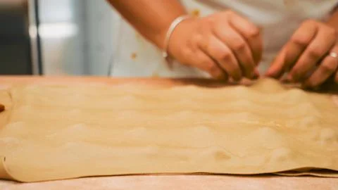 Woman's hands skillfully shaping handmade Italian tortellini with fresh pas.. Stock Photos