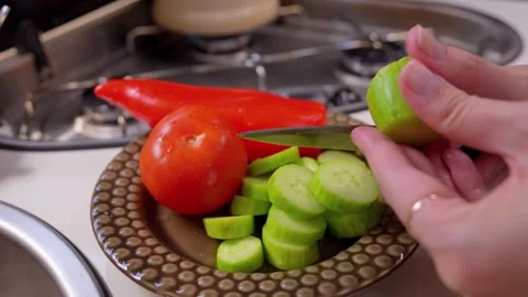 Woman's hands slicing fresh cucumber for salad 库存影片 340264721