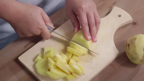 Woman's hands slicing potatoes Stock Footage 329684954