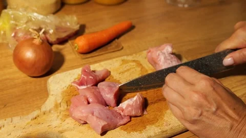 Woman's hands slicing raw pork meat for dinner preparation Video stock 342805794