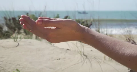 Woman's hands slowly dropping beach sand Stock-Footage 173976469