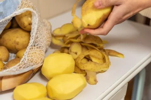 Womans hands with small kitchen knife. Potatoes peeling. Foto stock