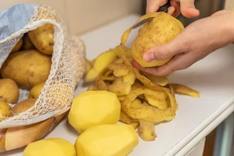 Womans hands with small kitchen knife. Potatoes peeling. Foto stock