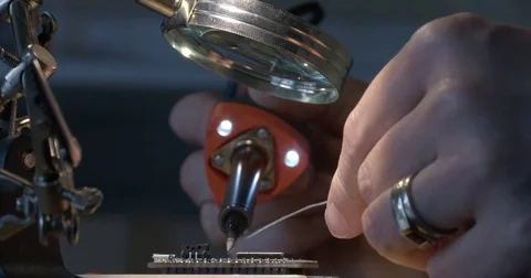 Woman's hands soldering electronics on small circuit board 4K Stockbeeldmateriaal 84960350