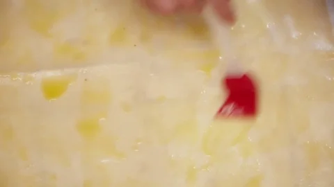 Woman's hands spreading the stirred eggs through the dough closeup Stock Footage 74463241