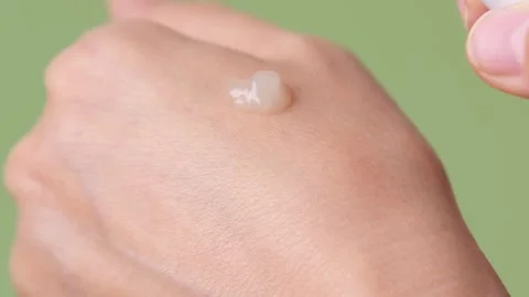 A womans hands squeeze out cream or serum for face, hand or body care and Stock Footage 321222437