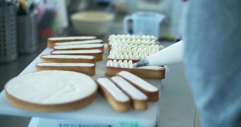 The woman's hands squeezing the cream on a cake and desserts. Tasty cream Stock Footage 135002757