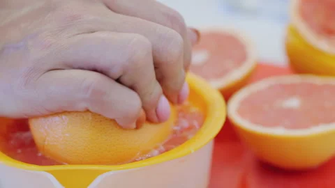 Woman's hands squeezing oranges in juicer Stock Footage 286706922