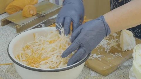 Woman's hands stir finely chopped cabbage and carrots Stock Footage 274432187