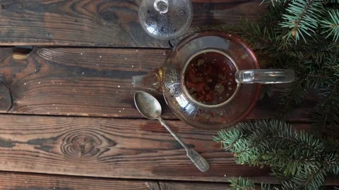 Woman's hands stir tea in a pot on a wooden table with fir branches Stock Footage 140808668