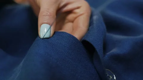 Woman's hands stitching button on a shirt in tailor shop. Close-up view. Stock Footage 152187157
