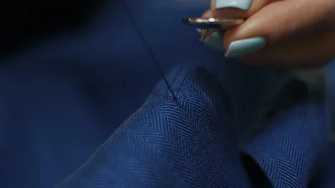 Woman's hands stitching button on a shirt in tailor shop. Close-up view. Stock Footage 152187201