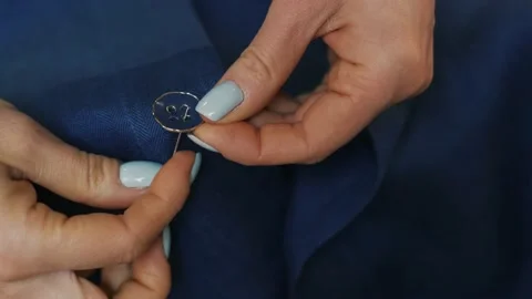 Woman's hands stitching button on a shirt in tailor shop. Close-up view. Stock Footage 152187312