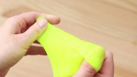Woman's hands stretch bright yellow slime Video stock 272319098