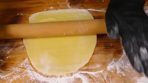 A woman's hands on the table rolling out thin dough Stock Footage 232726810