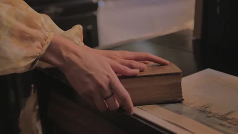 Woman's hands take and open a small elegant book. Stock Footage 149944772