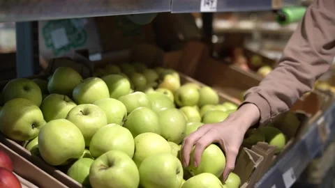 A woman's hands take a green apple from the shelf at the store Video stock 182011676