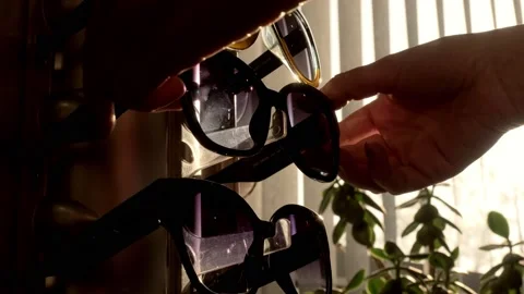 Woman's hands take a pair of sunglasses displayed in an optical shop Stock Footage 201539490