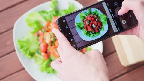Woman's hands take a picture of a vegetable salad using a smartphone. Close-up. Stock Footage 245285934