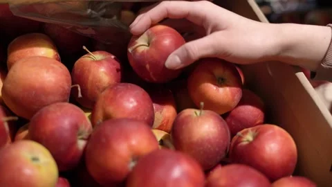 A woman's hands take a red apple from the shelf at the store Stock Footage 182027613