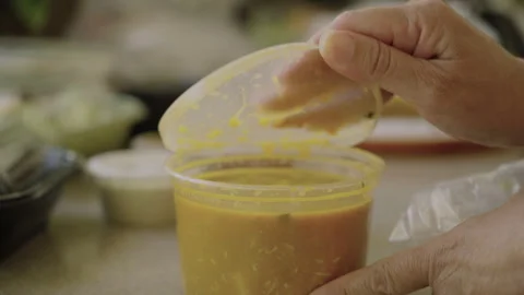 Womans hands taking off to go lid on soup container Video stock 284006998