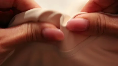 Woman's hands testing the texture of beige fabric by touch Stock Footage 319887952