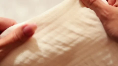 Woman's hands testing the texture of creamy-white fabric by touch Stock Footage 319887969