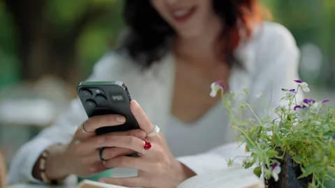 Woman's hands texting on a smartphone at an outdoor cafe Stock Footage 342741454