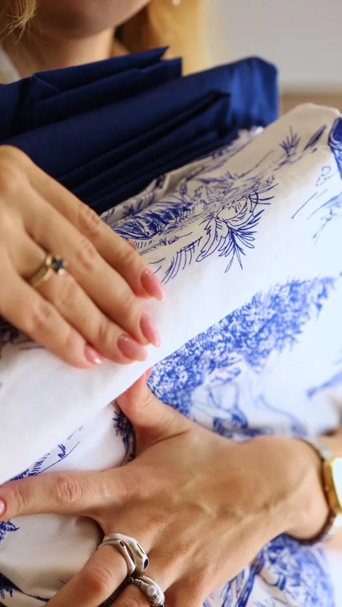 Woman's hands touching clean blue and white patterned bed linen. Stock Footage 321860780