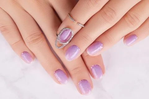 Womans hands with trendy lavender manicure. Spring summer nail design Stock Photos