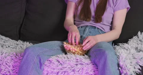 Woman's hands turn on the TV, remote control, start eating popcorn while sitting Vídeo Stock 244648784