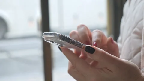 A womans hands type on a smartphone in a cozy cafe, reflecting modern technology Video stock 276540617