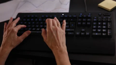 Womans hands typing on backlit computer keyboard Stock Footage 329224658