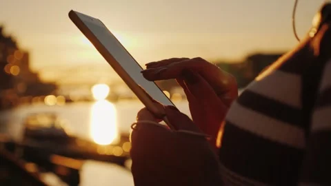 Woman's hands typing on smartphone screen during beautiful golden sunset, b.. Vídeo Stock 335065371