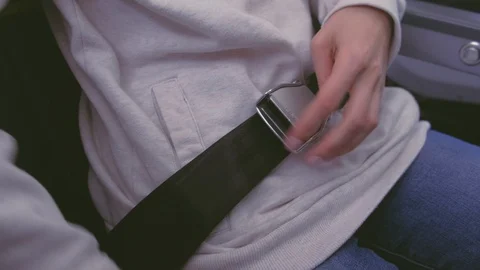Woman's hands unbuttoned safety seat belt on the plane. Hands close-up. Stock-Footage 115938341