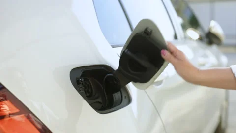 Woman's hands unplugging her electric automobile and closing the hatch in front 스톡 동영상 200832738