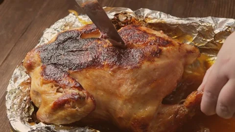 A woman's hands use a knife to cut a whole roast turkey with its crust on f.. Stock Footage 329502673