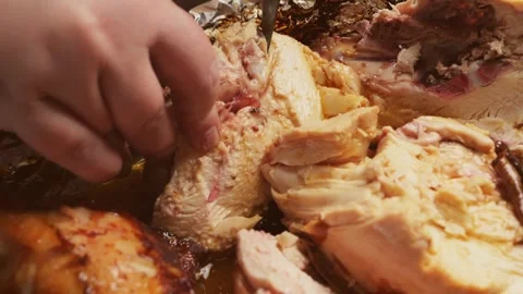 A woman's hands use a knife to cut a whole chicken baked with a spice crust.. Stock Footage 329503068