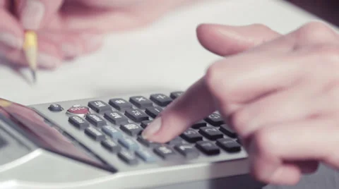 Woman's hands using a calculator and writing with a pencil on a paper Stock-Footage 48156810