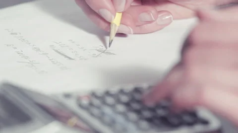Woman's hands using a calculator and writing with a pencil on a paper Video stock 48157764