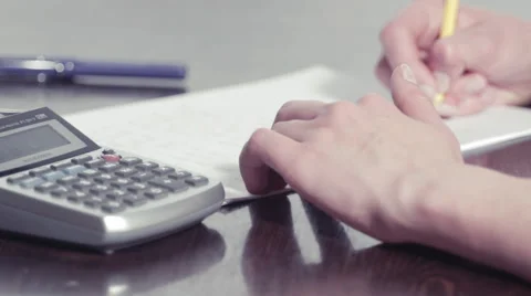 Woman's hands using a calculator and writing with a pencil on a paper 스톡 동영상 48158111