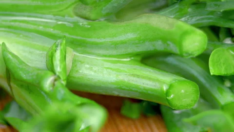 Woman's hands using kitchen knife cutting fresh kale on wooden cutting board. Stock Footage 140952775