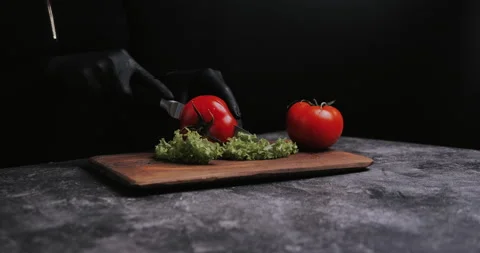 Woman's hands using kitchen knife cutting fresh tomato on wooden cutting board.  Video stock 148245022
