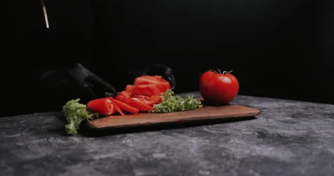 Woman's hands using kitchen knife cutting fresh tomato on wooden cutting board.  Video stock 148245195